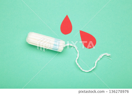 Composition with menstrual tampons and blood drop made of paper on mint background 136278976