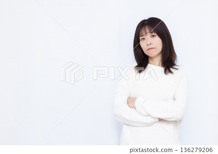 A woman thinking with her arms folded 136279206