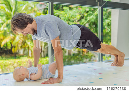 Father exercising with his small baby at home, active parenting and healthy lifestyle. Strong family bond, early physical development, modern fatherhood, fitness with children concept. Father exercising with his small baby at home, active parenting and healthy lifestyle. Strong family bond, early physical development, modern fatherhood, fitness with children concept. 136279588