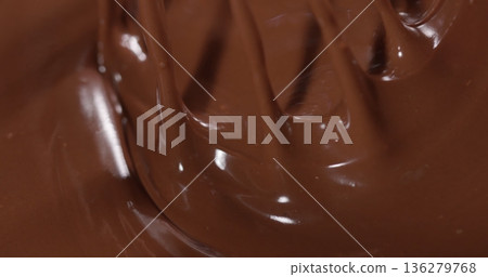 Melting chocolate swirls in a mixing bowl during the preparation of a dessert or confectionery at home Melting chocolate swirls in a mixing bowl during the preparation of a dessert or confectionery at home 136279768