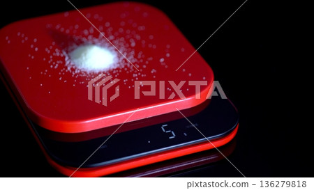 Weighing sugar on a digital scale in a kitchen setting during the evening hours Weighing sugar on a digital scale in a kitchen setting during the evening hours 136279818