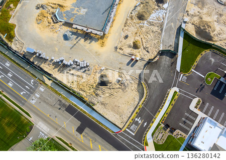 Workers are busy at construction site as new buildings take shape near road with active traffic. 136280142