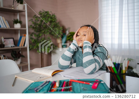 Tired girl feeling overwhelmed with homework and studying 136280712