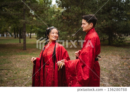 Interracial couple celebrating wedding wearing traditional red Chinese hanfu Interracial couple celebrating wedding wearing traditional red Chinese hanfu 136280788