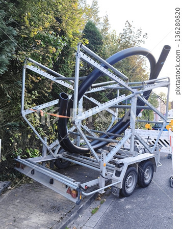 A trailer with a spool of large diameter black plastic pipes for laying communications A trailer with a spool of large diameter black plastic pipes for laying communications 136280820