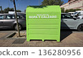 Urban clothing and footwear recycling bin by roadside, promoting sustainability 136280956