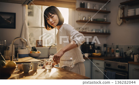 3. 一位日本女孩在廚房享用早餐，沐浴在清晨的陽光下。生活方式 136282044