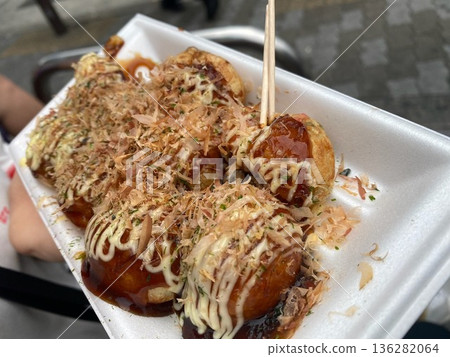 Freshly grilled takoyaki with dancing bonito flakes, a specialty of Osaka Freshly grilled takoyaki with dancing bonito flakes, a specialty of Osaka 136282064