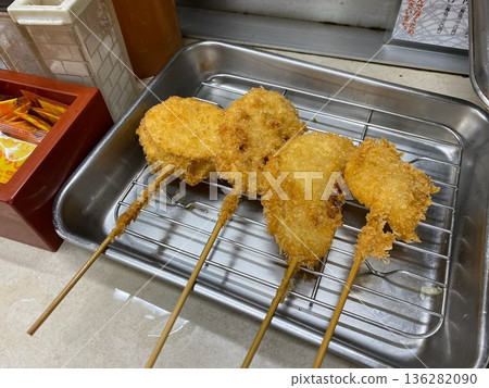 Four freshly fried skewers on a tray 136282090
