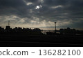Light shining through the gaps in the cloudy sky and the silhouette of the city 136282100