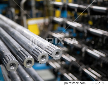 Metal splined shafts arranged in an industrial workshop. Precision-engineered components highlight manufacturing and machinery production Metal splined shafts arranged in an industrial workshop. Precision-engineered components highlight manufacturing and machinery production 136282199