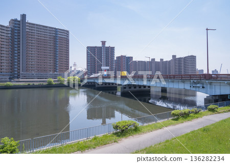 一個大型公寓大樓群和一條河床，河床上有一座大橋橫跨其上。 136282234