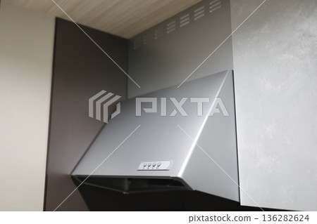 廚房裡安裝了一個銀色的抽油煙機通風系統。 廚房裡安裝了一個銀色的抽油煙機通風系統。 136282624