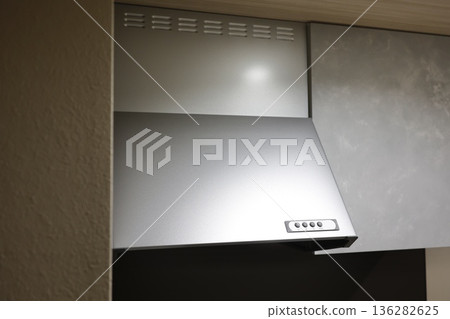 廚房裡安裝了一個銀色的抽油煙機通風系統。 廚房裡安裝了一個銀色的抽油煙機通風系統。 136282625