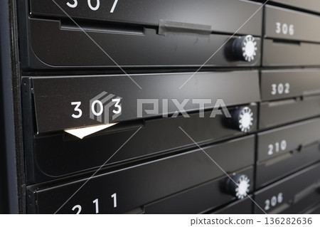 一張公寓大樓郵箱裡收到的棕色信封通知照片。 136282636