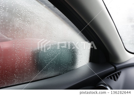The windows inside the car are fogged up, making it difficult to see the side mirrors, which is a dangerous situation. The windows inside the car are fogged up, making it difficult to see the side mirrors, which is a dangerous situation. 136282644
