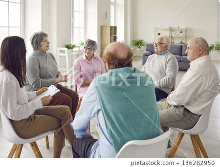 Young nurse, caregiver or psychologist woman having conversation with senior people. Young nurse, caregiver or psychologist woman having conversation with senior people. 136282950