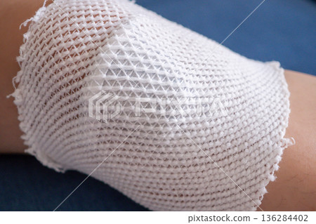 wound dressing bandage on child knee after fall on the ground 136284402