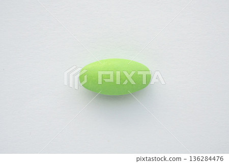 Green medicine pill tablet on white background 136284476