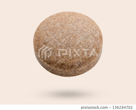 Brown herbal pill tablet flying on brown background Brown herbal pill tablet flying on brown background 136284702