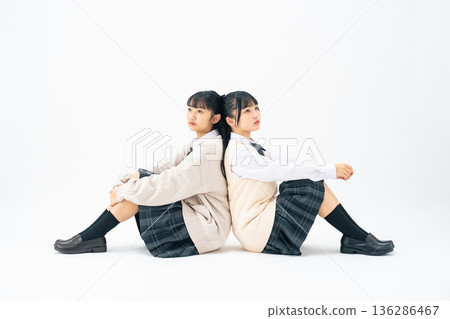 Two female students sitting back to back 136286467