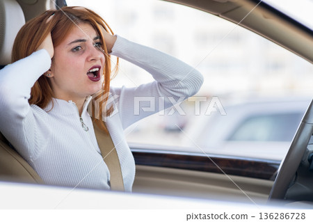 Closeup portrait of pissed off displeased angry aggressive woman driving a car shouting at someone. Negative human expression consept. 136286728