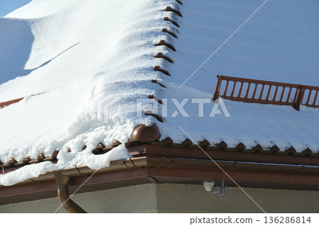 Snow guard for safety in winter on house roof top covered with ceramic shingles. Tiled covering of building Snow guard for safety in winter on house roof top covered with ceramic shingles. Tiled covering of building 136286814
