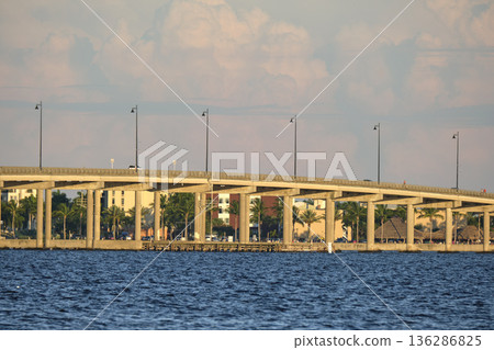 Barron Collier Bridge and Gilchrist Bridge in Florida with moving traffic. Transportation infrastructure in Charlotte County connecting Punta Gorda and Port Charlotte over Peace River Barron Collier Bridge and Gilchrist Bridge in Florida with moving traffic. Transportation infrastructure in Charlotte County connecting Punta Gorda and Port Charlotte over Peace River 136286825