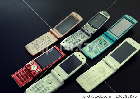 An old-fashioned flip phone placed on a white background 136286859