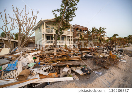 Piles of debris on street side in Florida. Hurricane aftermath cleanup. Garbage from severely damaged homes after storm surge. Consequences of natural disaster Piles of debris on street side in Florida. Hurricane aftermath cleanup. Garbage from severely damaged homes after storm surge. Consequences of natural disaster 136286887