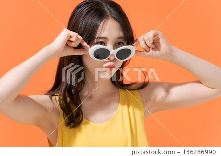 橘色背景上的微笑女子 136286990