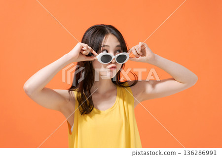 橘色背景上的微笑女子 136286991