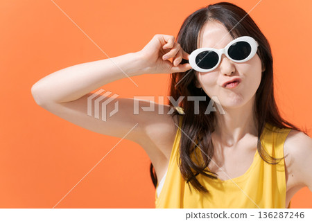 橘色背景上的微笑女子 136287246