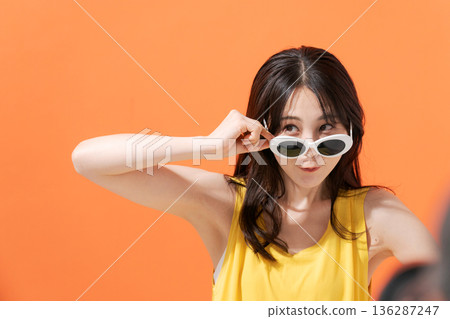 Smiling woman on an orange background 136287247