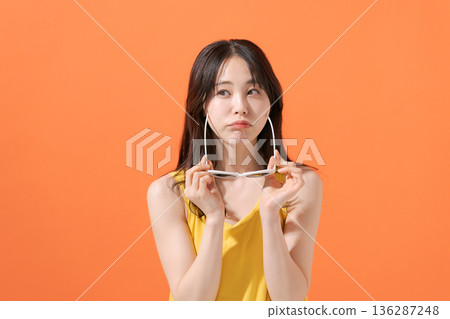 橘色背景上的微笑女子 136287248