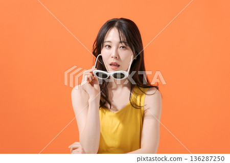 橘色背景上的微笑女子 136287250