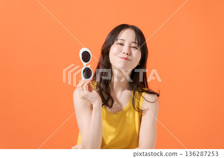 橘色背景上的微笑女子 136287253