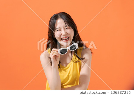 橘色背景上的微笑女子 136287255