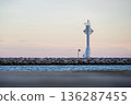 Minimal Lighthouse on Breakwater at Calm Sea and Pastel Sky 136287455