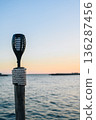 Outdoor Torch on Wooden Post by Sea at Sunset 136287456