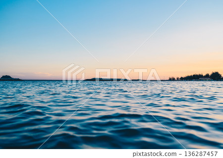 Calm Sea at Sunset with Horizon and Clear Sky 136287457