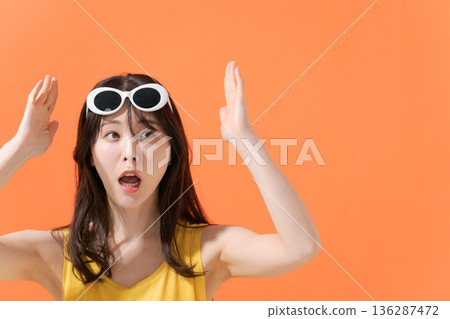 Smiling woman on an orange background 136287472