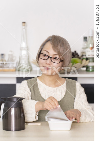 廚房裡,一位老婦人正往杯麵倒熱水。 廚房裡,一位老婦人正往杯麵倒熱水。 136287551