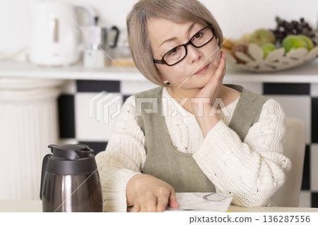 廚房裡,一位老婦人正往杯麵倒熱水。 廚房裡,一位老婦人正往杯麵倒熱水。 136287556