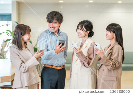 Smiling businessman and businesswoman looking at their smartphones (reviews, high ratings, word of mouth) 136288000