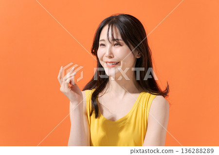 Smiling woman on an orange background Smiling woman on an orange background 136288289