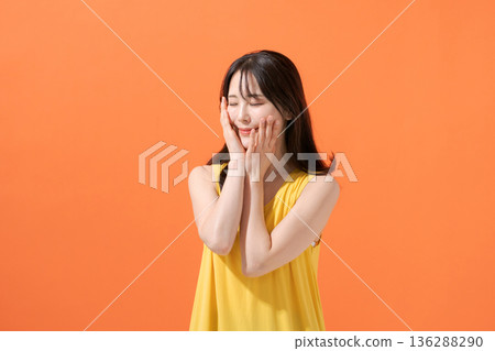 Smiling woman on an orange background Smiling woman on an orange background 136288290