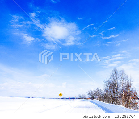 A landscape with a left-curve road in Biei, Hokkaido, under the blue sky in midwinter A landscape with a left-curve road in Biei, Hokkaido, under the blue sky in midwinter 136288764