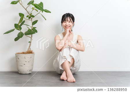 一位微笑的美麗亞洲女性坐在地板上（美極了，美極了） 136288950