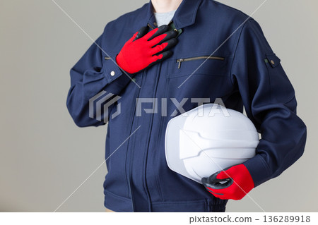 A middle-aged male businessman in work clothes holding a helmet and putting his hand on his chest A middle-aged male businessman in work clothes holding a helmet and putting his hand on his chest 136289918